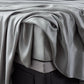 Close-up of Malouf botanical sheet set made with TENCEL Lyocell fiber, showcasing soft, smooth fabric and detailed corner stitching.