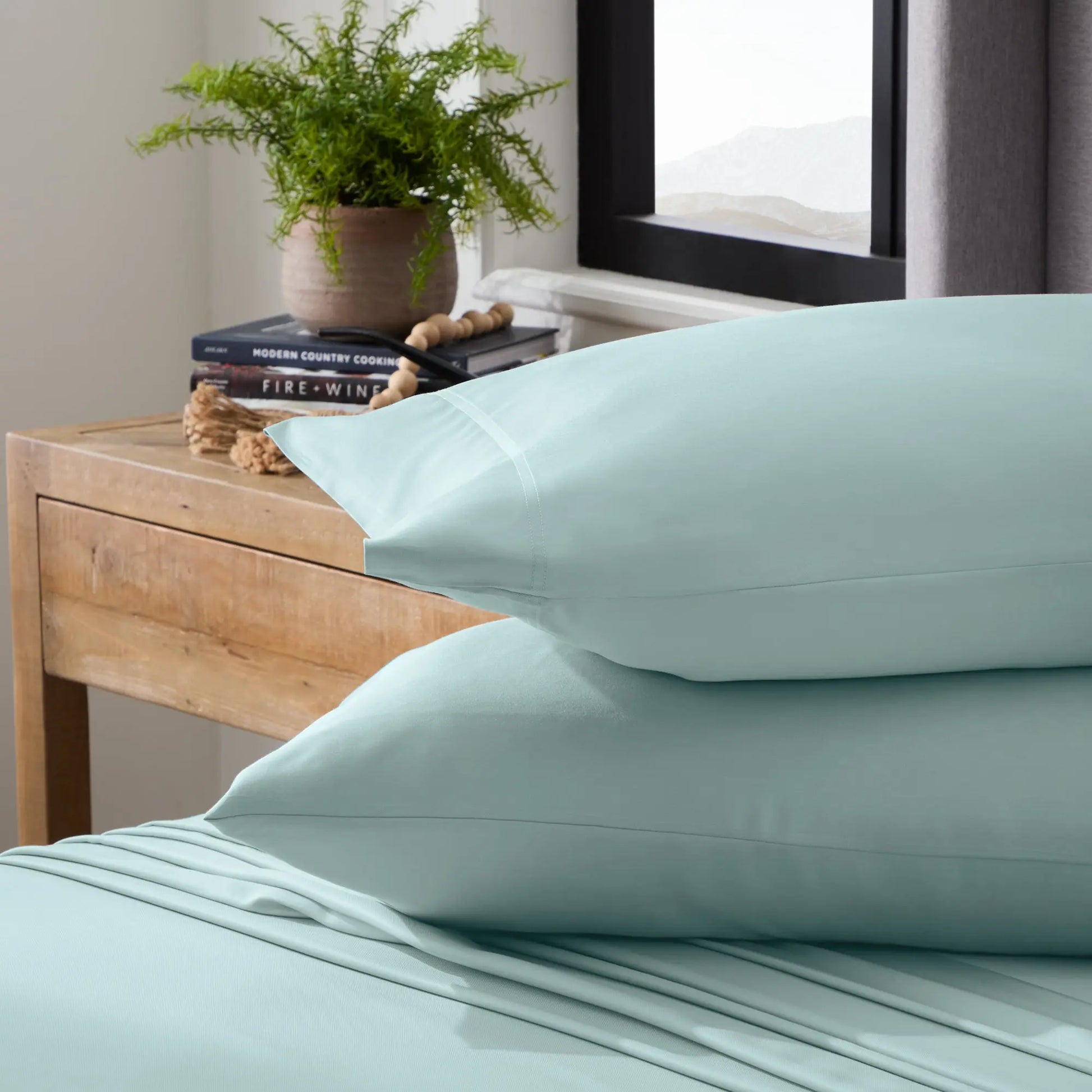 Malouf smooth bamboo rayon sheet set in ash color, showing soft, luxurious fabric and neatly folded bedding for a comfortable sleep.