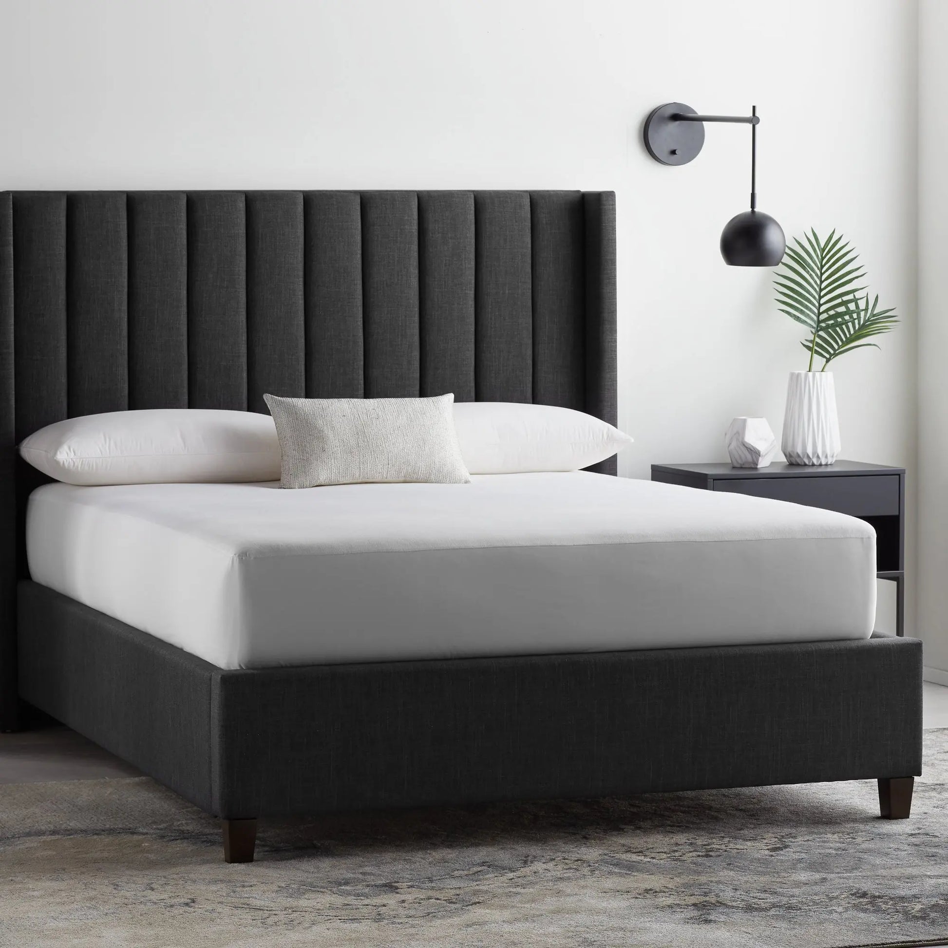 Malouf Five Sided and OmniPhase mattress protector on a bed, showing its fitted design and protective fabric for bedding.