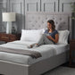 Malouf Eastman platform bed frame with a sturdy wooden design and neutral finish, shown in a spacious bedroom setting.