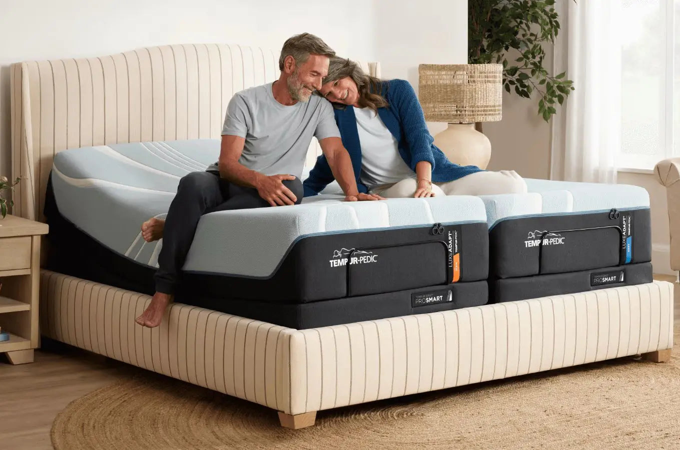 Split king TEMPUR-LuxeAdapt mattress by Tempur-Pedic with plush, undressed fabric cover, shown in a bedroom setting.